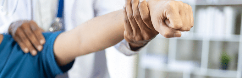 Doctor is diagnosing a man's arm and shoulder pain in a hospital examining room.