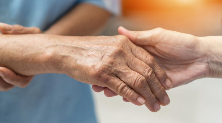 Arthritis person's hand in support of nursing family caregiver care for disability awareness day